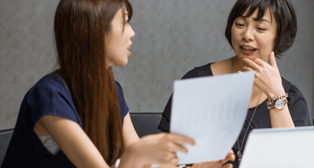 two people looking at paper and discussing