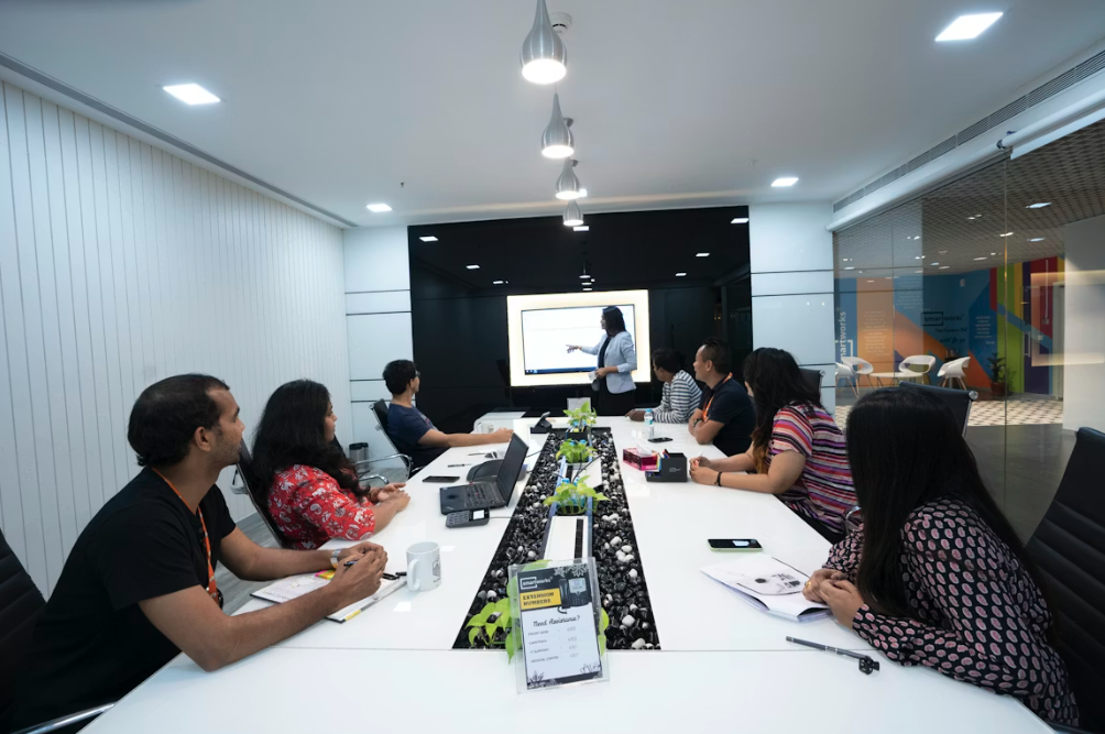 company meeting in an office with 8 people round a table
